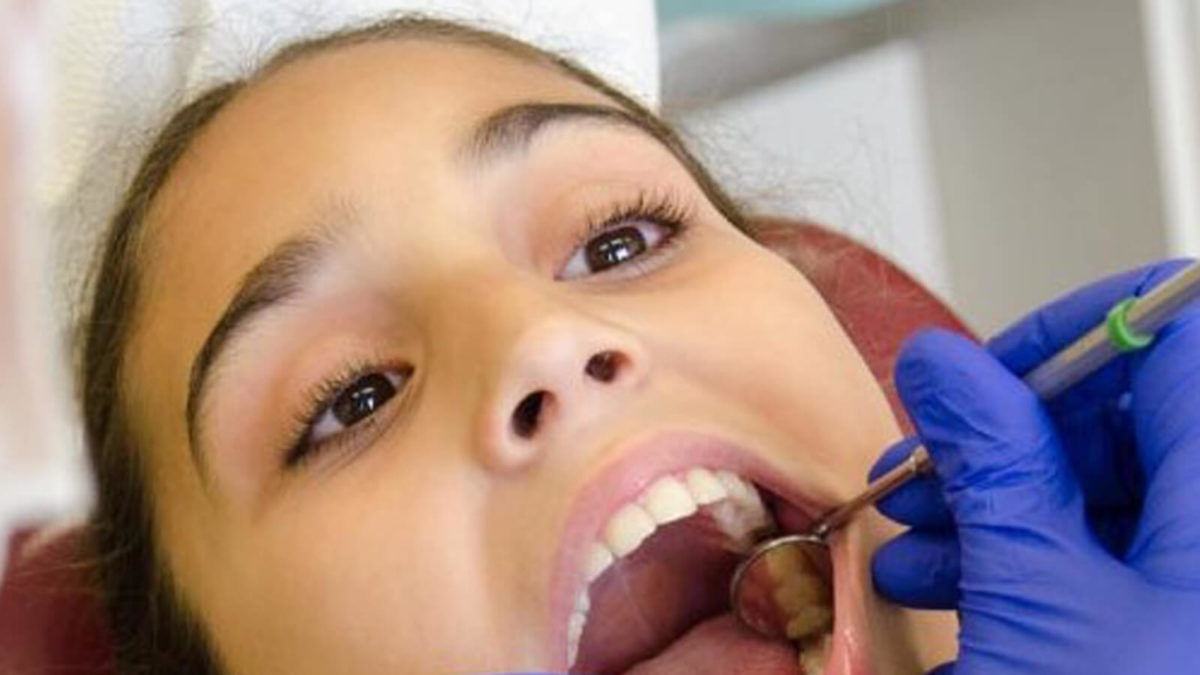 Girl having her teeth checked by a dental hygienist